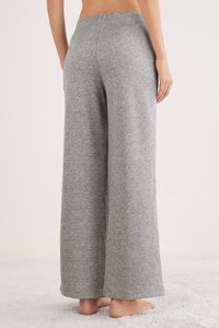 Pantalones grises de pierna ancha hechos de una suave tela mezcla de algodón. Presentan una cintura elástica y diseño de longitud completa, con una textura jaspeada.