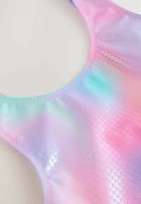 Zbliżenie na opalizującą tkaninę z różowymi, fioletowymi i niebieskimi odcieniami oraz małymi, okrągłymi cekinami przyszytymi różową nicią.