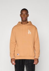 Hoodie beige en tissu doux, avec une poche kangourou à l'avant, un capuchon à cordon et un logo LA blanc sur la poitrine gauche.