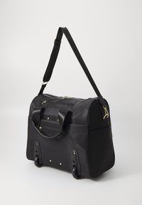 Fekete kerekes sporttáska tartós szövetből. Arany részletekkel, dupla fogantyúkkal, levehető vállpánttal és cipzáras zsebbel rendelkezik.