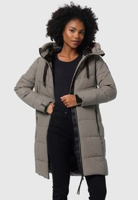 Gevoerde olijfgroene parka met een capuchon, ritssluiting aan de voorkant en accentbanden. Heeft horizontale quilt en zwarte mouwmanchetten.