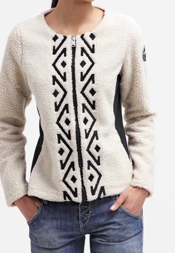 Kurtka polarowa z kremowym przodem i czarnymi panelami bocznymi, z geometrycznym czarnym wzorem wzdłuż środka i zamkiem błyskawicznym.