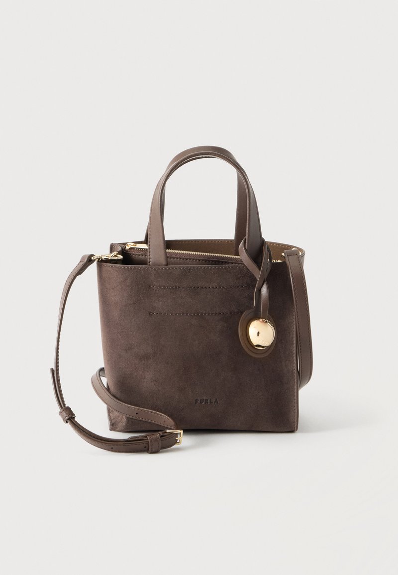 Sac à main en daim et cuir marron avec poignées supérieures, une bandoulière amovible, une fermeture éclair dorée et un charm décoratif rond doré.