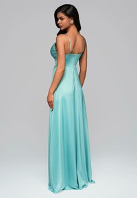 Bodenlanges aquafarbenes Satin-Kleid mit dünnen Trägern, tailliertem Oberteil und sanftem Fall. Die Rückseite zeichnet sich durch eine dezente Formgebung und einen Reißverschluss aus.