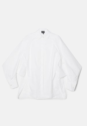 Camicia bianca in cotone con colletto classico, maniche lunghe e taglio dritto con fessure laterali. Polsini con bottone e una texture liscia.