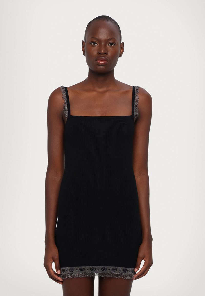 Robe noire à côtes avec décolleté carré, fines bretelles et franges grises complexes au niveau de l'ourlet. Le tissu est lisse avec une coupe ajustée.