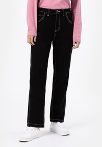 Black jeans with contrast white stitching, featuring a straight leg design, five pockets, and a button closure at the waistband.