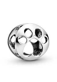 Charm in argento con design circolare caratterizzato da impronte di zampe ritagliate e fori, finitura liscia e superficie lucidata. Accentuato con dettagli neri.