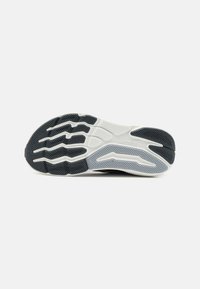 Schuhsohle mit einem Schwarz-Weiß-Farbschema, strukturiertem Gummi und einem wellenförmigen Muster für Traktion und Stabilität.