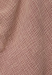 Tissu rose doux avec un motif en grille froissé texturé et des plis subtils créant de la profondeur et des ombres.