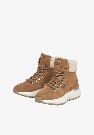 Kahvinsi väriset korkeakantaiset saappaat, joissa on karvaremmi ja hopeiset silmukat. Saappaissa on teksturoidut pohjat ja kengännauhat, ja ne on suunniteltu mukavuuden ja tyylin yhdistämiseksi.