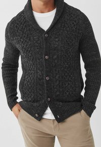 Ciemnoszara dziergana kamizelka z kołnierzem szalowym, z teksturowanymi wzorami, pięcioma brązowymi guzikami oraz prążkowanymi mankietami i dołem.
