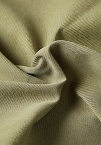 Tessuto verde oliva di texture con una superficie morbida e tessuta, che mostra una leggera elasticità e una finitura liscia, leggermente opaca.