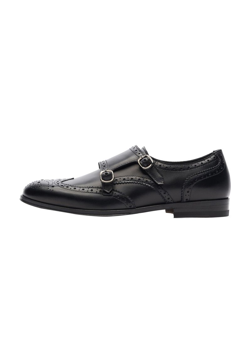 Scarpa da uomo in pelle nera con doppia fibbia, dettagli brogue sulla punta, forma arrotondata e tacco basso. Texture liscia nel complesso.