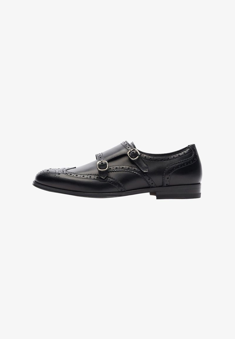 Schwarze Lederlackschuhe mit doppeltem Schnallen-Design, Broguedetails an der Zehe, runder Form und niedrigem Absatz. Insgesamt glatte Oberfläche.