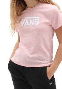 Jasnoróżowa koszulka z krótkim rękawem z białym logo Vans z przodu. Wykonana z miękkiego materiału bawełnianego, z okrągłym dekoltem i luźnym krojem.