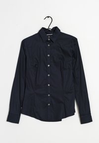 Mörkblå långärmad skjorta med knappar och krage, med en slät textur, silverknappar och två bröstfickor framtill.