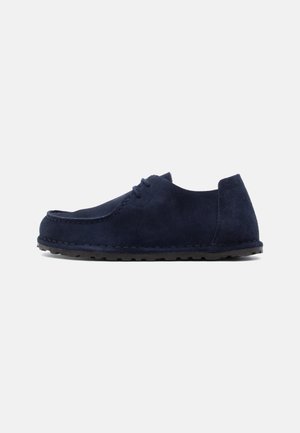 Navy blue suede casual moccasin shoe with black rubber sole and lace-up front, shown in a side profile on a white background.