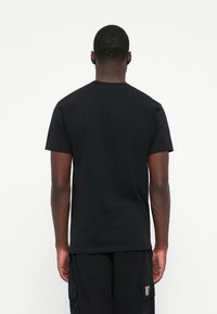 Black cotton t-shirt displayed from the back, featuring a classic crew neck design and short sleeves, plain without patterns or accents.