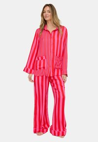 Rotes und pink gestreiftes Satin-Pyjama-Set mit langärmligem, knöpfbarem Oberteil mit zwei Taschen und passenden, locker sitzenden Hosen.
