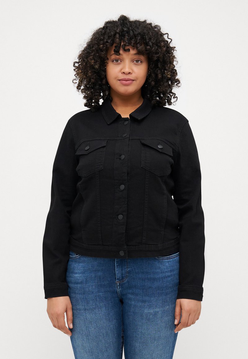 Black denim jacket with long sleeves, front button closure, two chest pockets, and a cropped design. Worn with blue jeans.