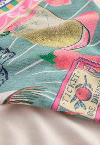 Spalvinga medžiaga su tropinių gėrimų iliustracijomis, žalia, rožine ir kreminės spalvos, su vintage bilieto dizainu ir tekstūruotais detalėmis.