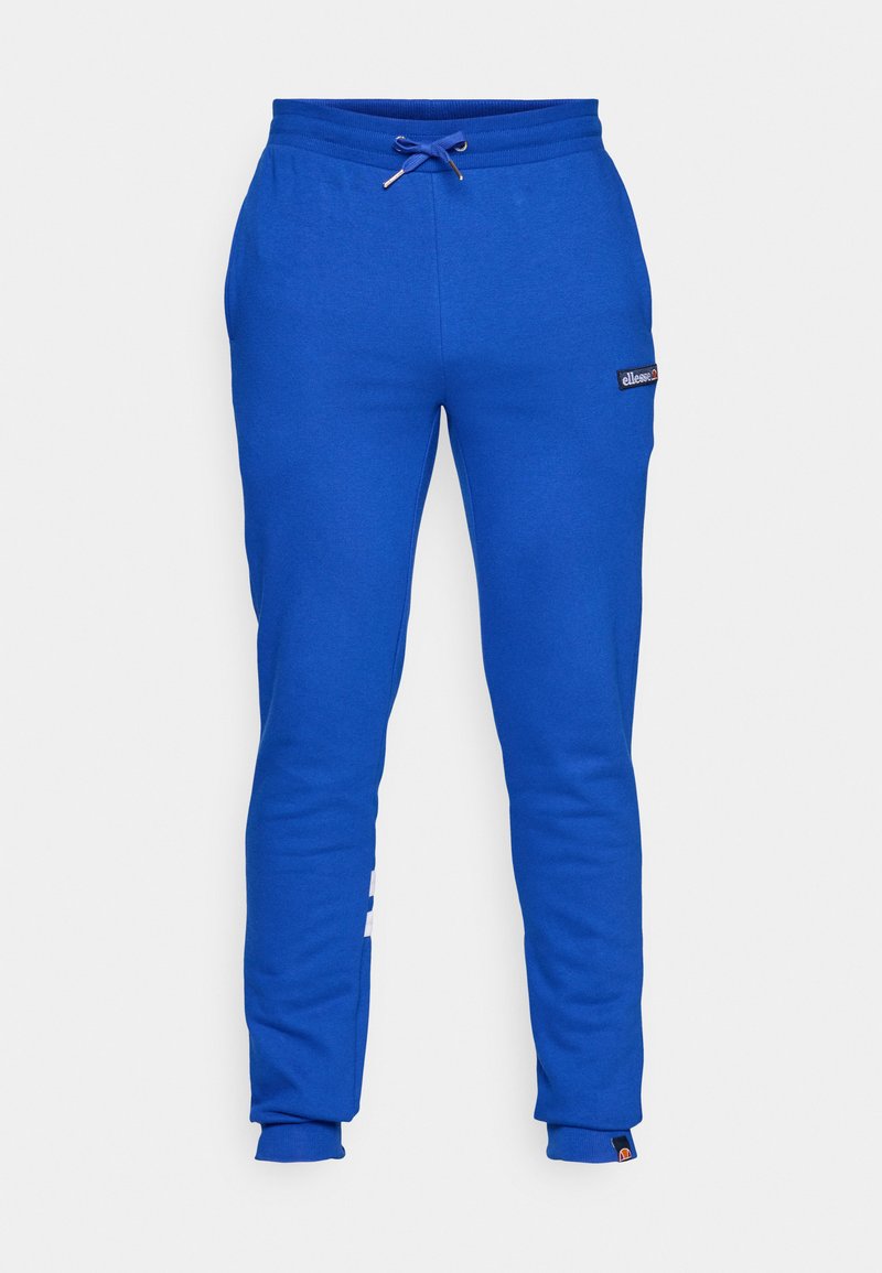 Pantalones de chándal azul entallados con cinturilla elástica y cordón, bolsillos laterales y pequeños parches de logo blanco en el muslo y el tobillo.