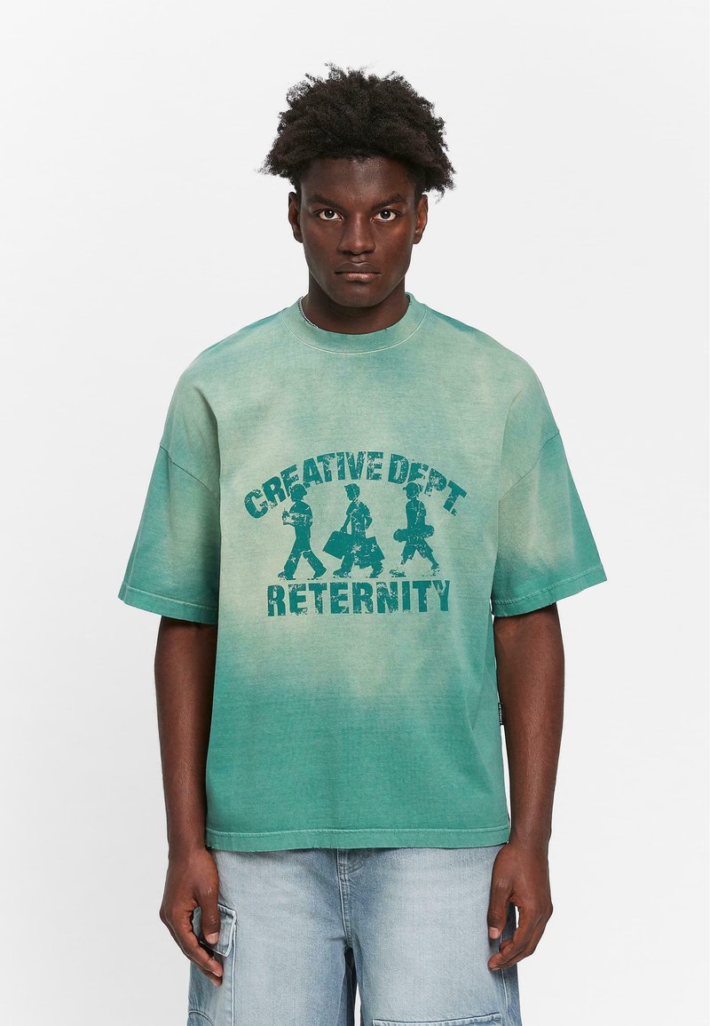 Grøn gradient oversized t-shirt med rund halsudskæring og korte ærmer. Indeholder teksten "CREATIVE DEPT" og "RETERNITY" med grafiske figurer.
