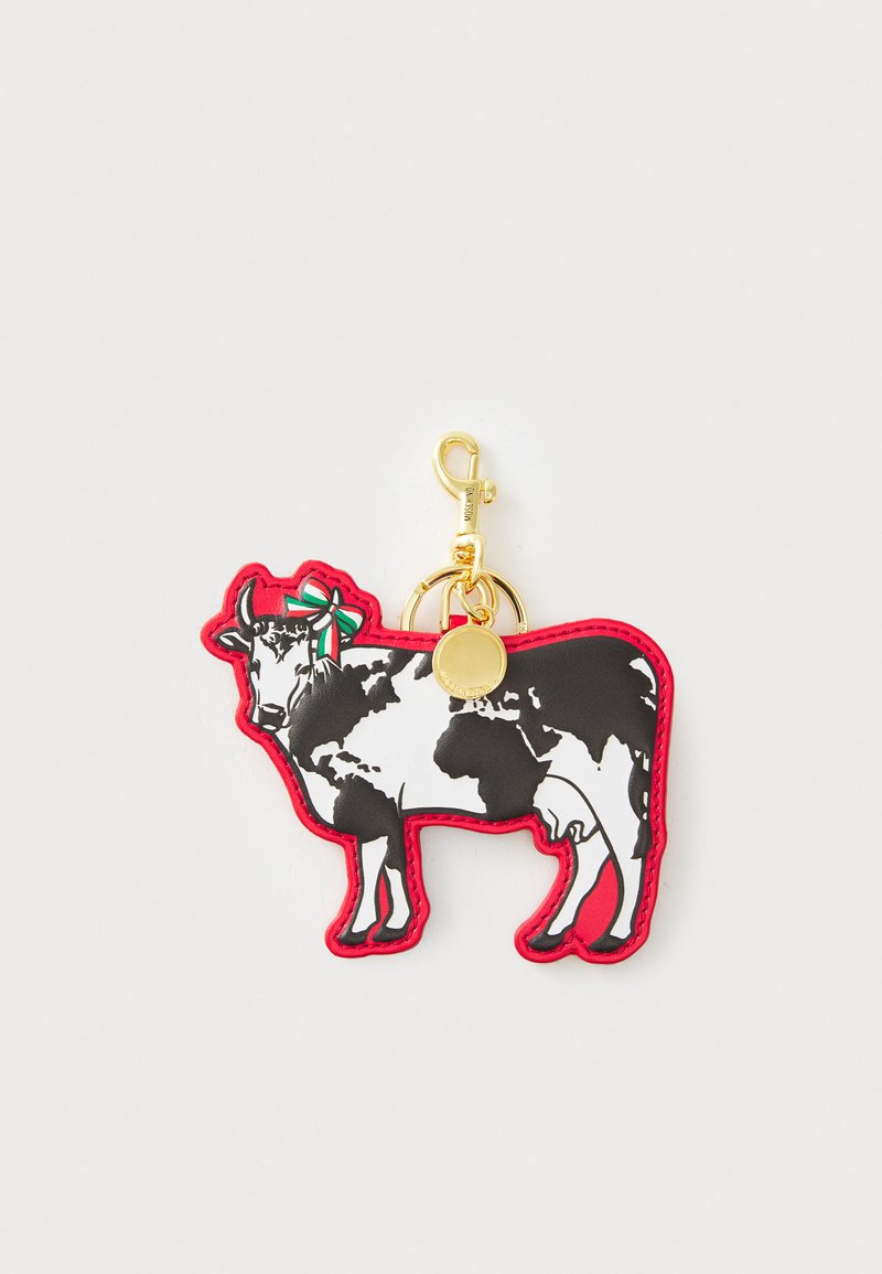 Creative keychain shaped like a cow, made of black and white rubber with a red border. Features a gold clip and a decorative bow.