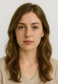 Porträtt av en person med långt, vågigt brunt hår, iförd en ljusbeige v-ringad tröja, med klar hy och neutral sminkning.