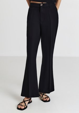 Pantaloni a zampa nera con una texture liscia, caratterizzati da una chiusura con bottone anteriore, tasche laterali e dettagli di piega sottili.