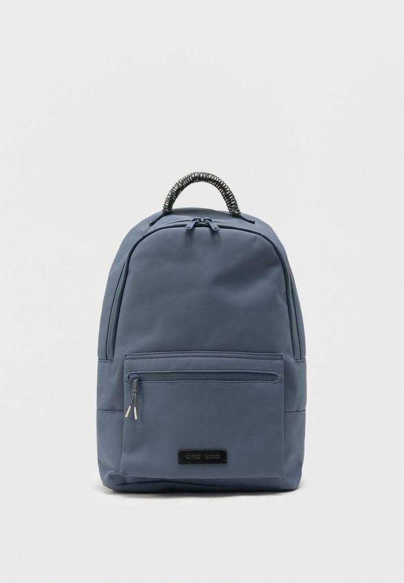 Μπλε σακίδιο με μπροστινή τσέπη με φερμουάρ και πλεγμένη κορυφαία λαβή σε απλό ανοιχτό φόντο.