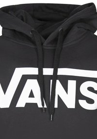 Felpa nera con cappuccio, tasca frontale a marsupio, cordini e un logo "VANS" bianco ben visibile. Materiale morbido con una superficie liscia.