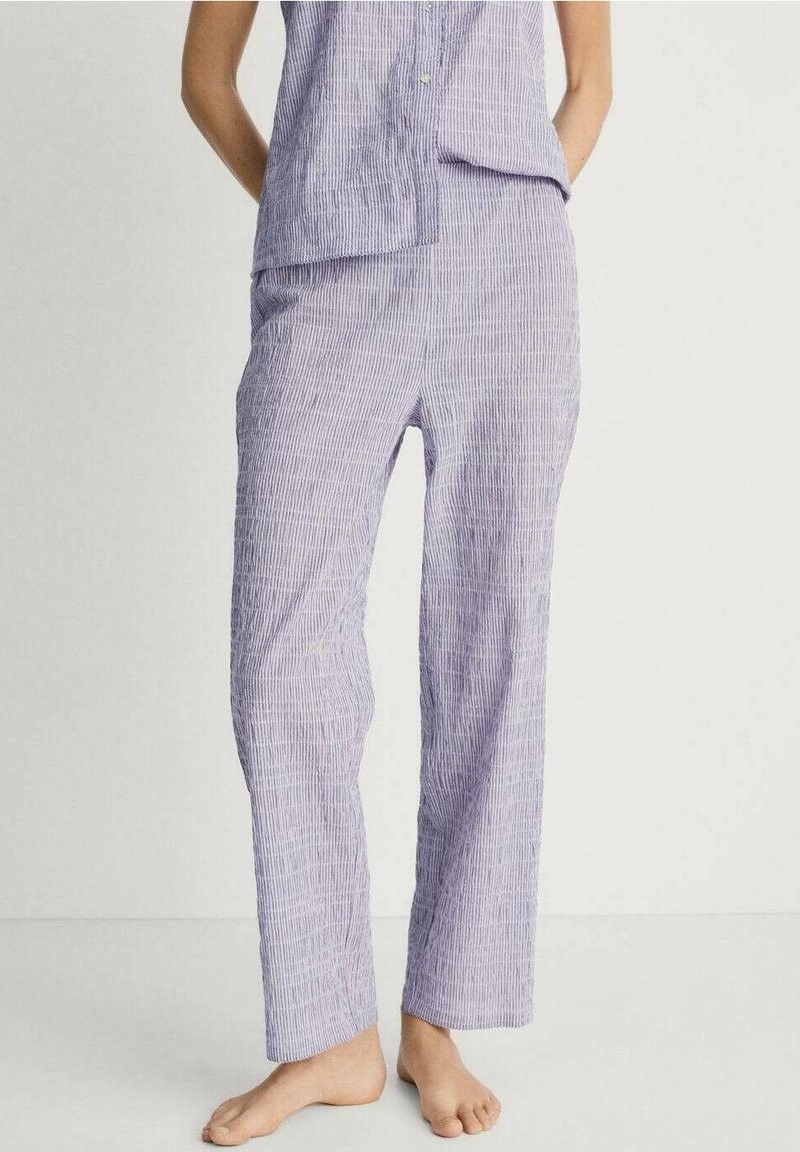 Lichtpaarse pyjama set met verticale witte strepen; het topje heeft knopen en een ontspannen pasvorm; de broek heeft een rechte pijpstijl en zijzakken.