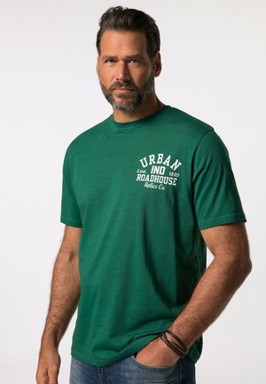Grünes T-Shirt mit kurzen Ärmeln aus Baumwolle. Mit einem weißen Druckdesign auf der Vorderseite, runden Ausschnitt und lockerer Passform.