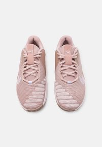 Scarpe da ginnastica rosa con tomaia in rete traspirante, dettagli cuciti, lacci piatti e suola texturizzata con accento bianco.