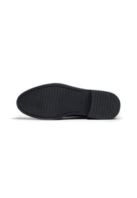 Semelle de chaussure en caoutchouc noir avec une surface texturée et des rainures horizontales pour une meilleure adhérence, bout arrondi et légère courbure pour le confort.