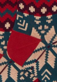 Calze di lana con un motivo multicolore di rosso, teal, crema e navy, adornate da forme geometriche e con tallone e punta rossi.