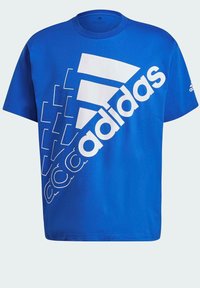 Modrá bavlněná tričko s velkým bílým logem "adidas" a šikmými pruhy. Krátké rukávy a kulatý výstřih.