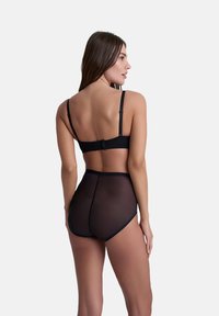 Set di lingerie nera composto da un reggiseno in tessuto liscio e elasticizzato con spalline regolabili e slip alti in rete trasparente.