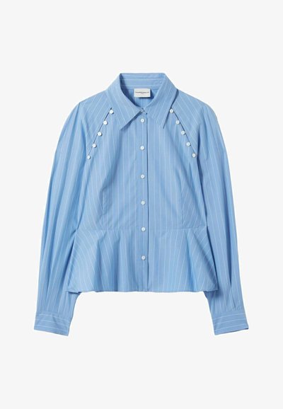 Camicia button-up azzurro chiaro con righe verticali bianche, orlo peplum, maniche lunghe e bottoni decorativi sulle spalle. Tessuto di consistenza liscia.