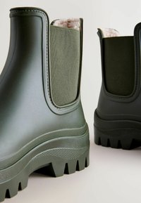 Groene rubberen enkellaarsjes met een gestructureerde afwerking, elastische zijpanelen en een zachte binnenvoering. Voorzien van een robuuste, met noppen beklede zool.