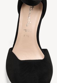 Chaussure plate en daim noir avec bout carré et semelle intérieure beige affichant le nom de la marque et la taille F 1/2 à l'intérieur.