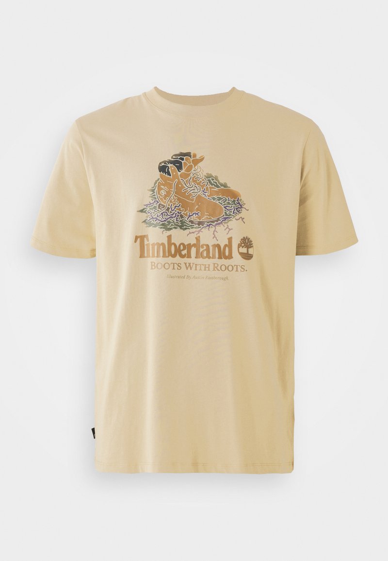 Beige Baumwoll-T-Shirt mit einer grafischen Illustration von Stiefeln und dem Text "Timberland Boots With Roots" darunter. Kurze Ärmel, lässige Passform.