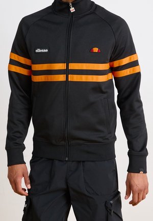 Sort lynlåstrøje med to vandrette orange striber over bryst og ærmer, Ellesse-logoer på venstre bryst og lynlåstrækker.