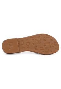 Suola di scarpe in gomma marrone chiaro con un motivo di presa testurizzato, design piatto e dettagli del logo in rilievo. Finitura liscia, materiale resistente.