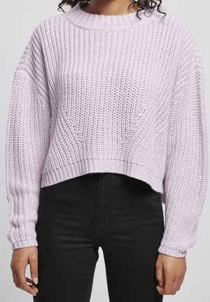 Pull court en lilas tricoté avec un large col et des poignets côtelés, présentant un motif texturé et une coupe décontractée. Associé à un pantalon noir.