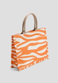 Orange und weiße Stofftasche mit Zebra-Streifen-Muster, ausgestattet mit zwei hellbraunen Griffen und einer strukturierten rechteckigen Form.