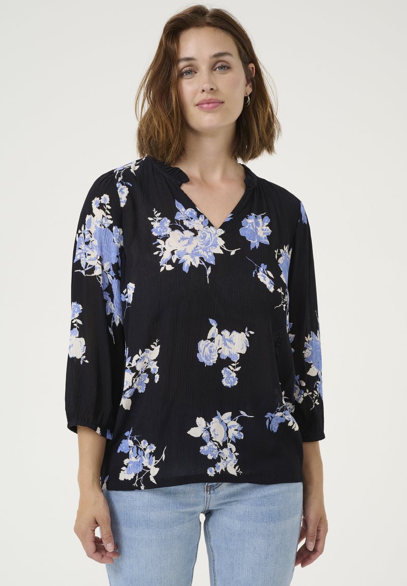Blusa nera floreale con fiori blu e bianchi, scollatura a V e maniche a tre quarti, realizzata in un tessuto testurizzato e con collo arricciato.
