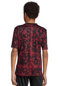 Camisa de manga corta de tela negra con un patrón de flores y vides en rojo oscuro, con un escote redondo y una textura suave.
